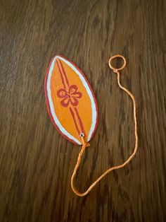 an orange and white bag on a wooden table with a string hanging from it's side