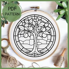 a cross stitch pattern with a tree in the center and leaves on it, surrounded by scissors