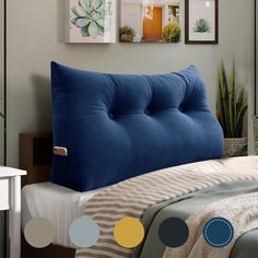 a bed with a blue headboard sitting next to a plant and pictures on the wall