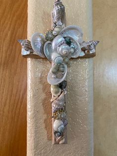 a cross made out of seashells on a wall