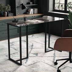 an office with a desk and chair in the corner, next to a potted plant