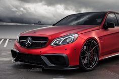 a red mercedes benz c63 amg coupe car parked in a parking lot