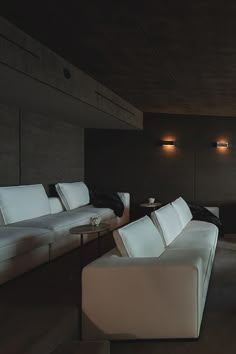 a living room filled with white couches next to a wall mounted flat screen tv