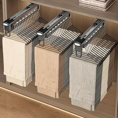 three towels are hanging on the rack in front of a bookcase with folded books