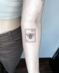 a woman's arm with a tattoo on it that has a bee on it