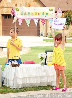 two young children standing under an umbrella at a birthday party