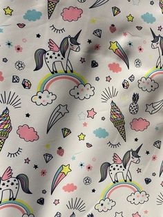 a white fabric with unicorns and rainbows on it's sides, all in different colors