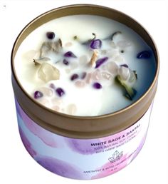 a candle that is sitting inside of a tin with flowers on the top and bottom