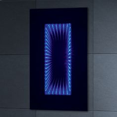 a black wall with blue lights on it and a square shaped object in the middle