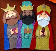 three paper dolls with crowns and beards on top of a wooden table next to each other