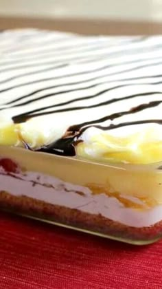 there is a dessert in the glass dish on the red tablecloth with white and black stripes