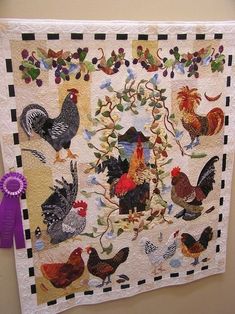 a quilt hanging on the wall with roosters and hens all over it's border