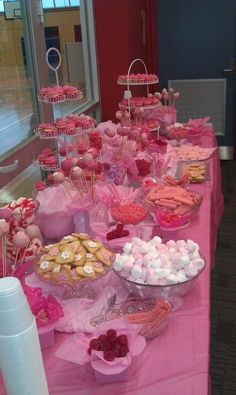 a pink table topped with lots of desserts