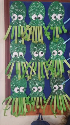 an art project with green paper cut outs and eyes