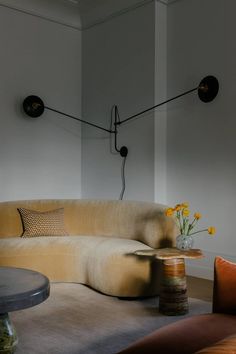 a couch and table in a room with two lamps on the wall behind it,