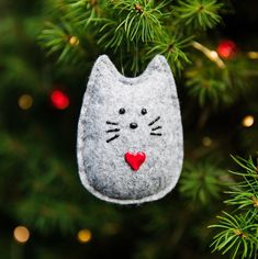 a felt cat ornament hanging from a christmas tree