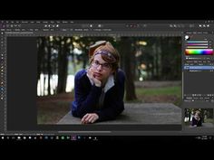 a woman with glasses is sitting on a bench in front of trees and has her hand under her chin