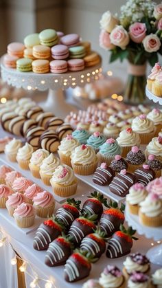 a table topped with lots of different types of cupcakes