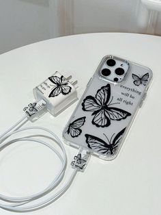 an iphone case with butterflies on it sitting next to a charger