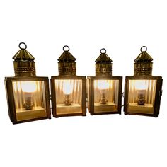 three old fashioned lanterns with lights on them