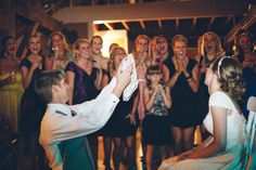 a group of people standing and sitting around each other at a wedding or another event