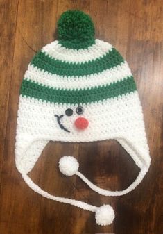 a crocheted snowman hat on top of a wooden table