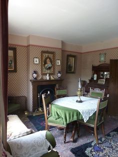 an old fashioned dining room with antique furniture and paintings on the wall behind the table