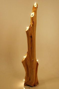 a wooden object with some lights on it's side and a white wall in the background