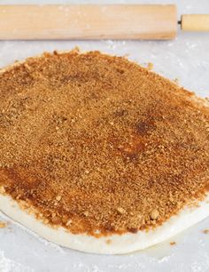 an uncooked pizza sitting on top of a table next to a rolling pin