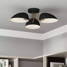 three lights are hanging from the ceiling in a room with bookshelves and shelves