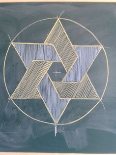 a drawing on a blackboard with lines in the shape of an inverted star and cross