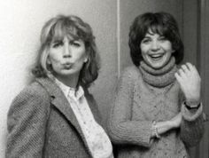 two women standing next to each other in front of a mirror with their mouths open