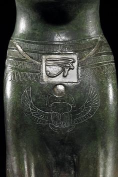 an egyptian statue is shown in green and black colors, with symbols on the body