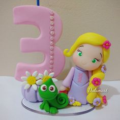 there is a cake that has the number three on it and a doll next to it