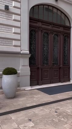 a large white planter sitting on the side of a building next to a door