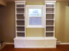 an empty room with built in bookshelves and windows