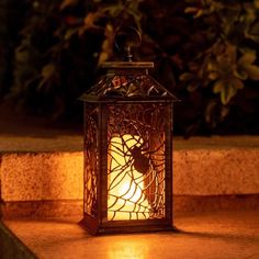 a lit lantern sitting on top of a stone step