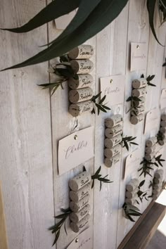 a wooden board with lots of small rocks and greenery on the top, along with name tags attached to it