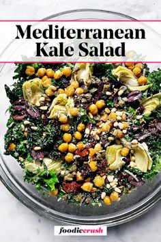 a salad with chickpeas and kale in a glass bowl