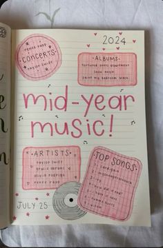 an open notebook with the words mid - year music written in pink and black on it