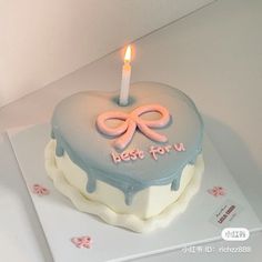 a heart shaped cake with a lit candle on it's top that says best for u