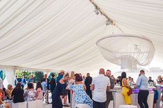 a group of people standing under a white tent