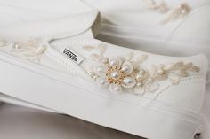 a pair of white shoes with pearls on them