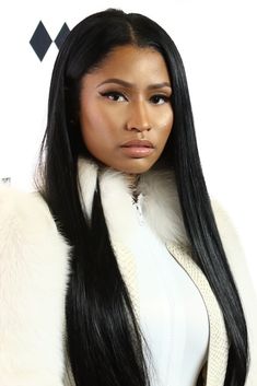 a woman with long black hair wearing a fur coat