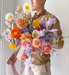 a man holding a bouquet of flowers in his hands