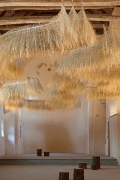 several straw umbrellas hanging from the ceiling