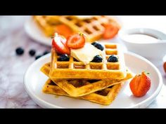 waffles with fruit and cream on them are sitting on a plate