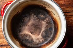 a pot filled with liquid sitting on top of a wooden table