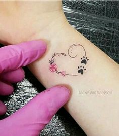 a person with a small tattoo on their left arm and paw prints on the wrist