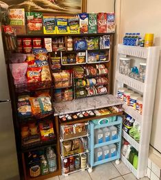 a refrigerator and shelves filled with food in a kitchen